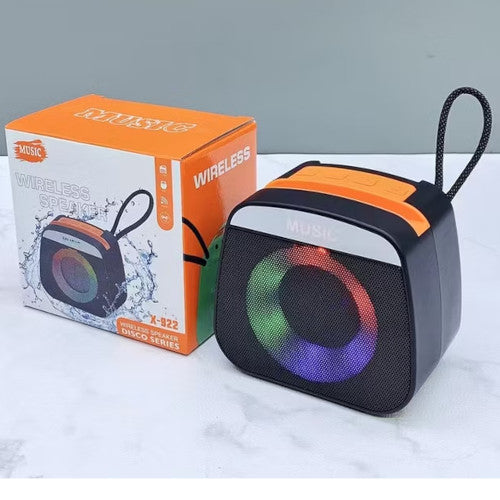 Wireless speaker with colorful LED lights next to its packaging on a white surface.